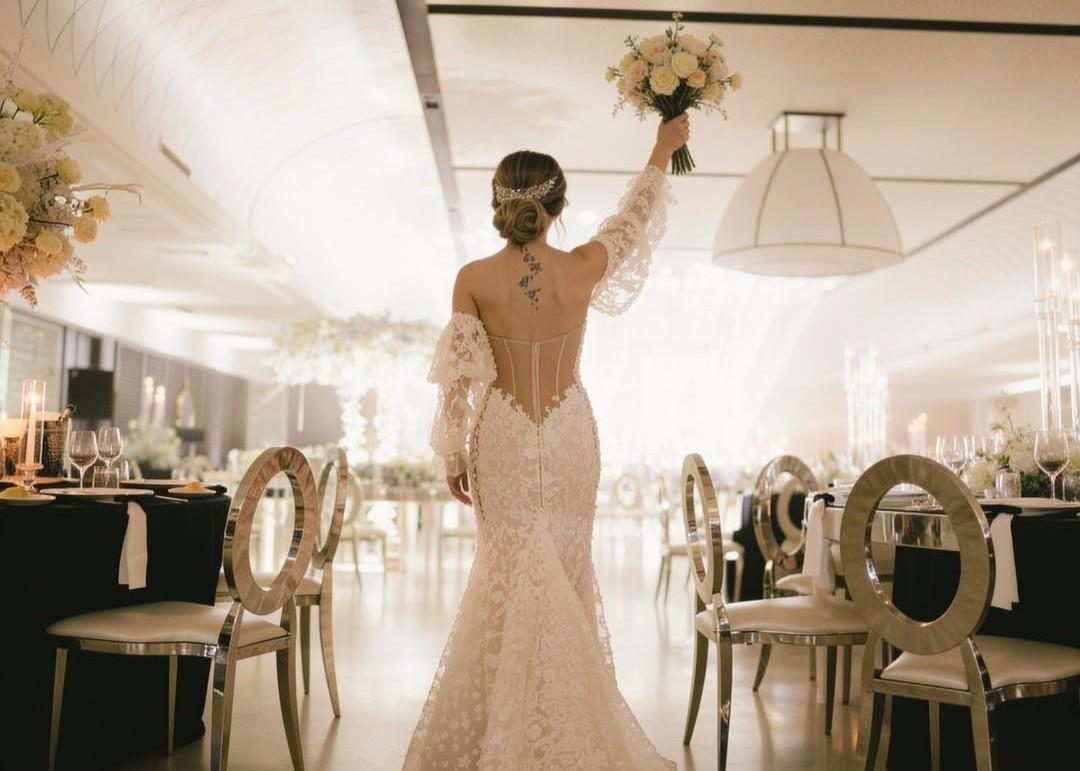 Mariée vêtue d'une robe sirène en dentelle avec un bouquet de fleurs, lors d'une élégante réception de mariage.