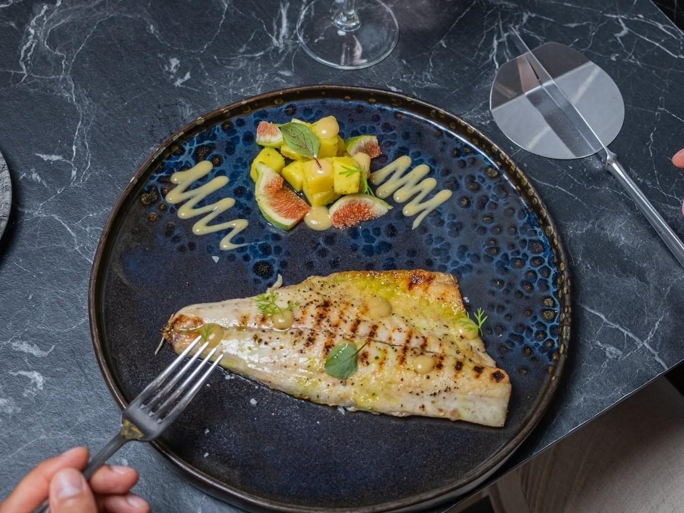 Fish dish with a side of potatoes and figs.