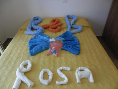 Double bed decorated with rolled towels arranged into letters and figures, in towel art style.