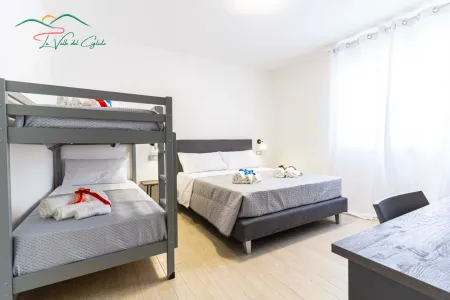 Helles Schlafzimmer mit einem Doppelbett und einem Etagenbett, ideal für Familien oder Gruppen.