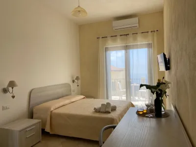 Helles und einladendes Doppelzimmer, schlicht und modern eingerichtet mit Doppelbett, hellen Nachttischen aus Holz, Lichtvorhängen und Klimaanlage.