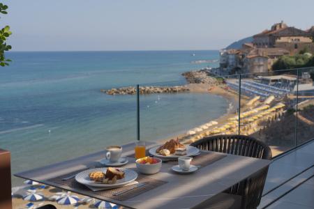 Colazione in terrazza vista mare, con caffè, croissant e pasticcini.