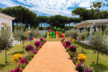 Entrance to the children's play area, featuring a brick pathway and colorful flower beds.