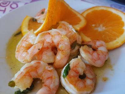 Piatto a base di pesce, con gamberi e arance.