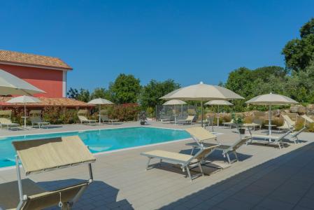 Swimming pool at Terra di Vento farmhouse with sun loungers and parasols.
