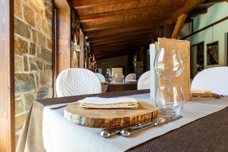 Ristorante rustico ed elegante con tavola apparecchiata in legno, pietra e dettagli raffinati.