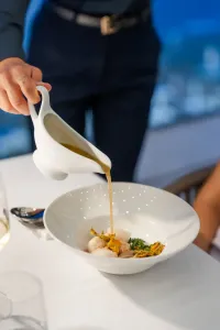 Chef versa una salsa calda su un piatto gourmet al ristorante Donna Elisa del Grand Hotel Santa Maria.