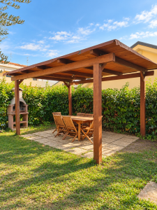 Private garden with a wooden pergola, outdoor table and chairs, built-in barbecue and green hedge.